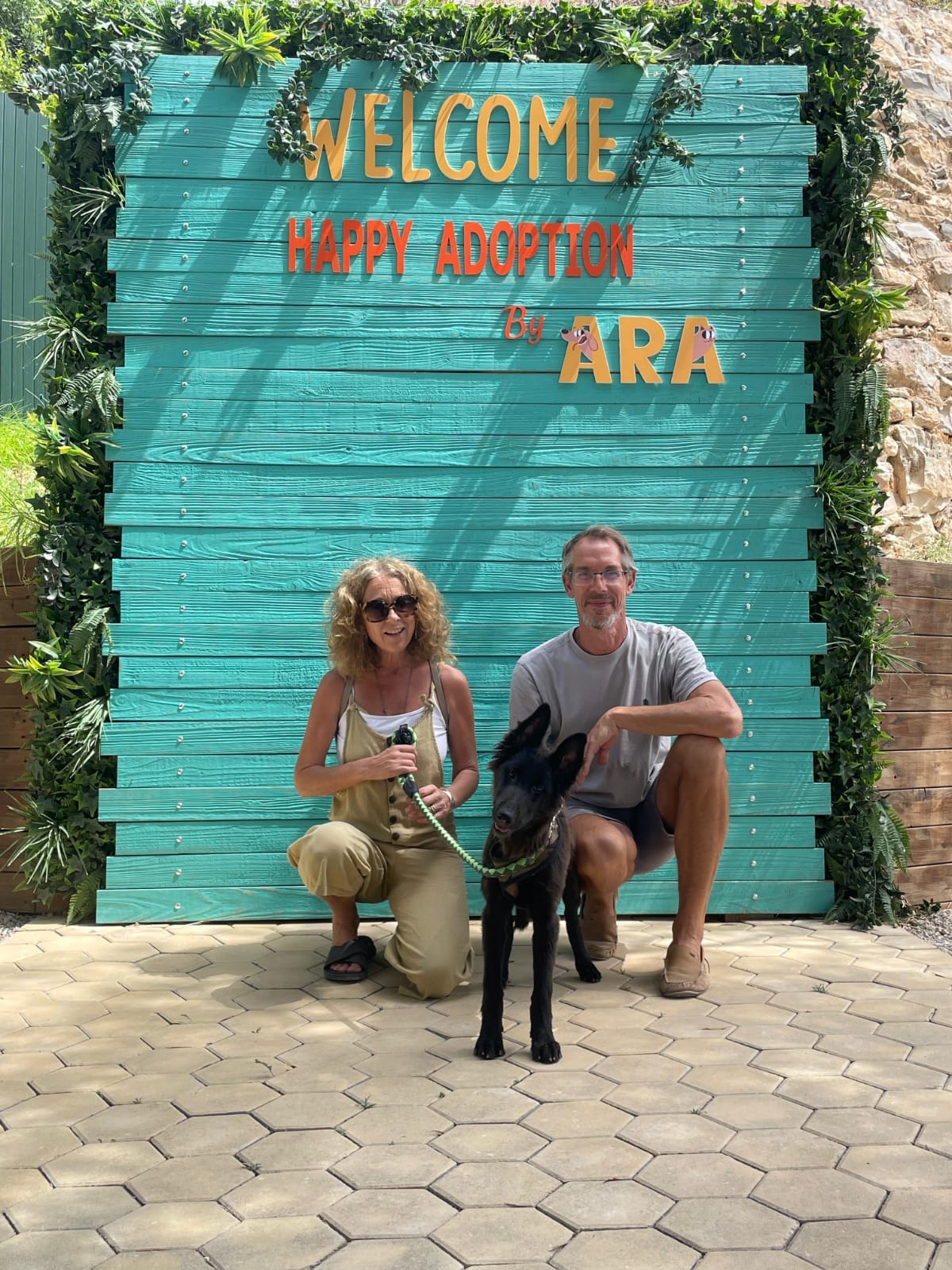 My friends Ellen and Charlie with Lula in front of the ARA sign that is a very pretty teal blue with a welcome message and plants growing around it and I'm sorry, that's kind of a shit description. Must. Do. Better.