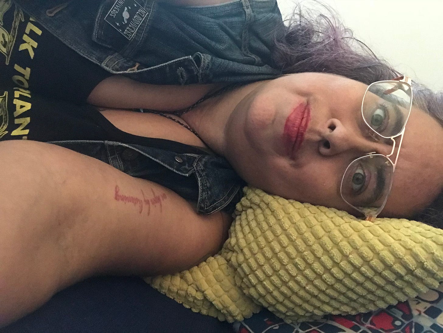 Photograph of author Leah Lakshmi Piepzna-Samarasinha, light sand skinned non-binary femme, wearing glasses and laying on her side on a green pillow. Photograph of author Leah Lakshmi Piepzna-Samarasinha, light sand skinned non-binary femme, wearing glasses and laying on her side on a green pillow.