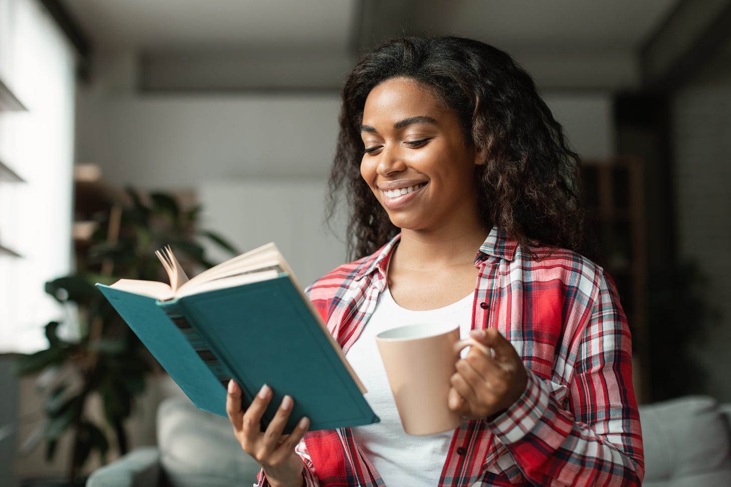 black girl enjoys a book and coffee