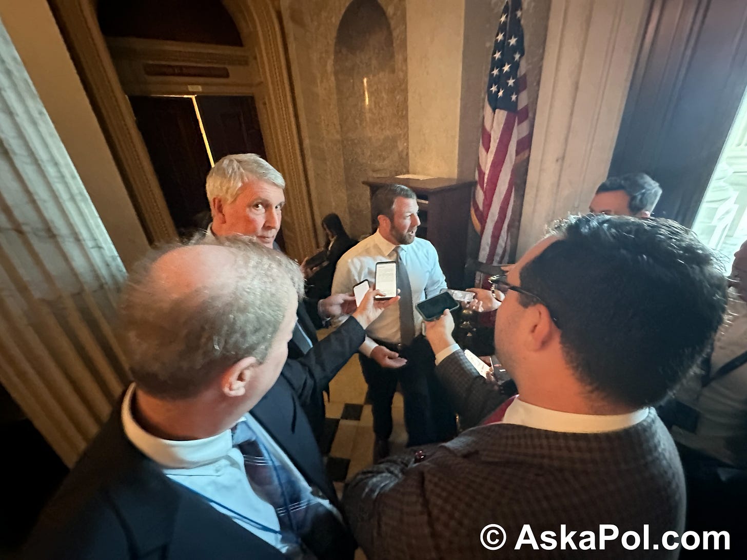 Man in tie and suit is asked questions by reporters Photo: Matt Laslo © www.askapol.com