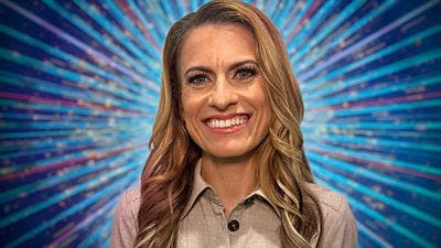 A head and shoulders shot of Karen Carney, wearing a beige linen style shirt, smiling to camera against a glittering blue background