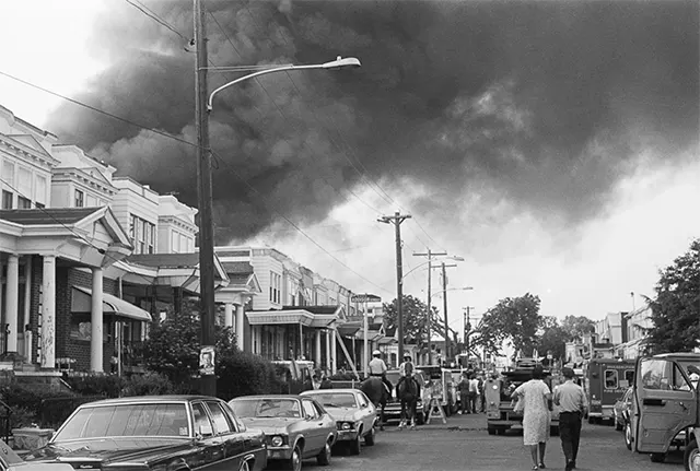Thick smoke billows ominously from the rapidly spreading fire in the wake of the devastating bombing.