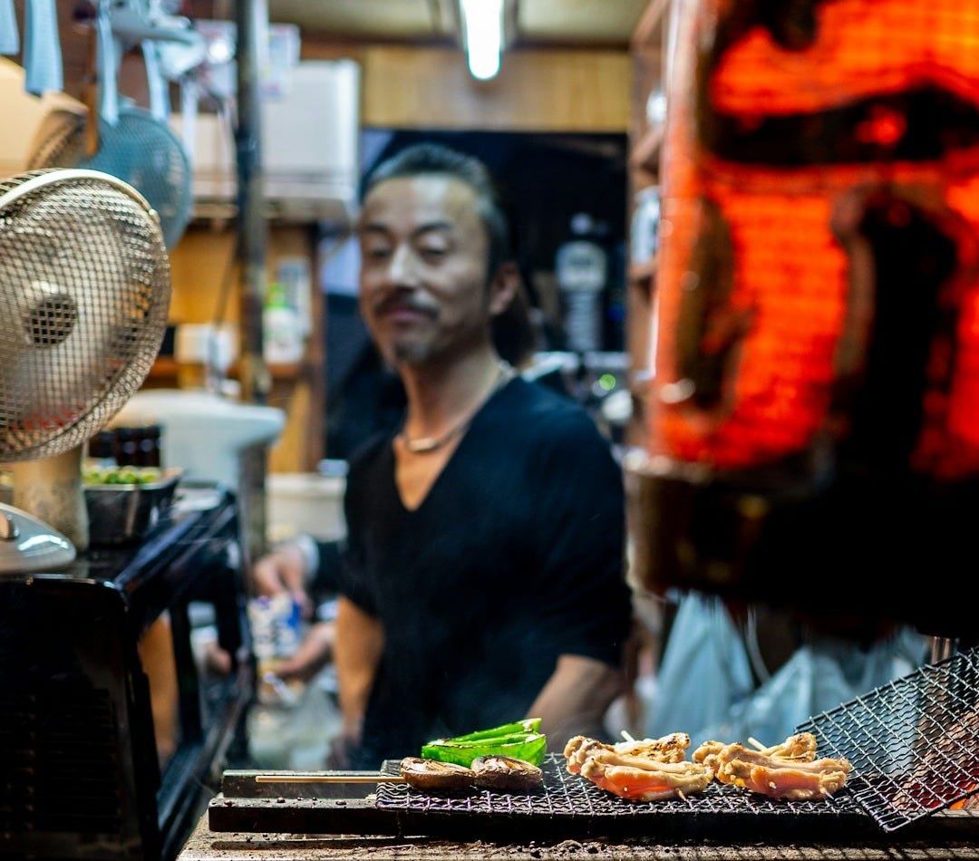 a man standing in a kitchen preparing food a man standing in a kitchen preparing food