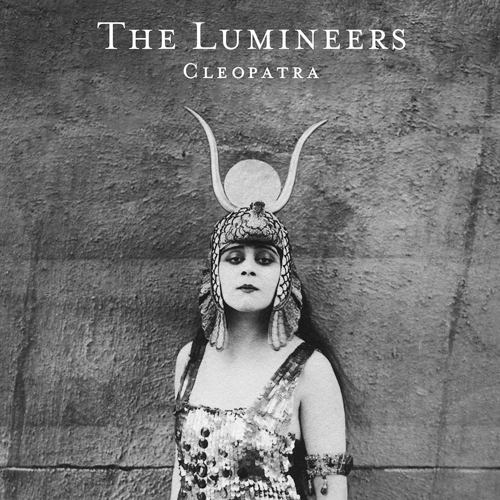 Album cover for The Lumineers second studio album Cleopatra has a lady in black and white with a hat with horns on her head in black and white photo Album cover for The Lumineers second studio album Cleopatra has a lady in black and white with a hat with horns on her head in black and white photo