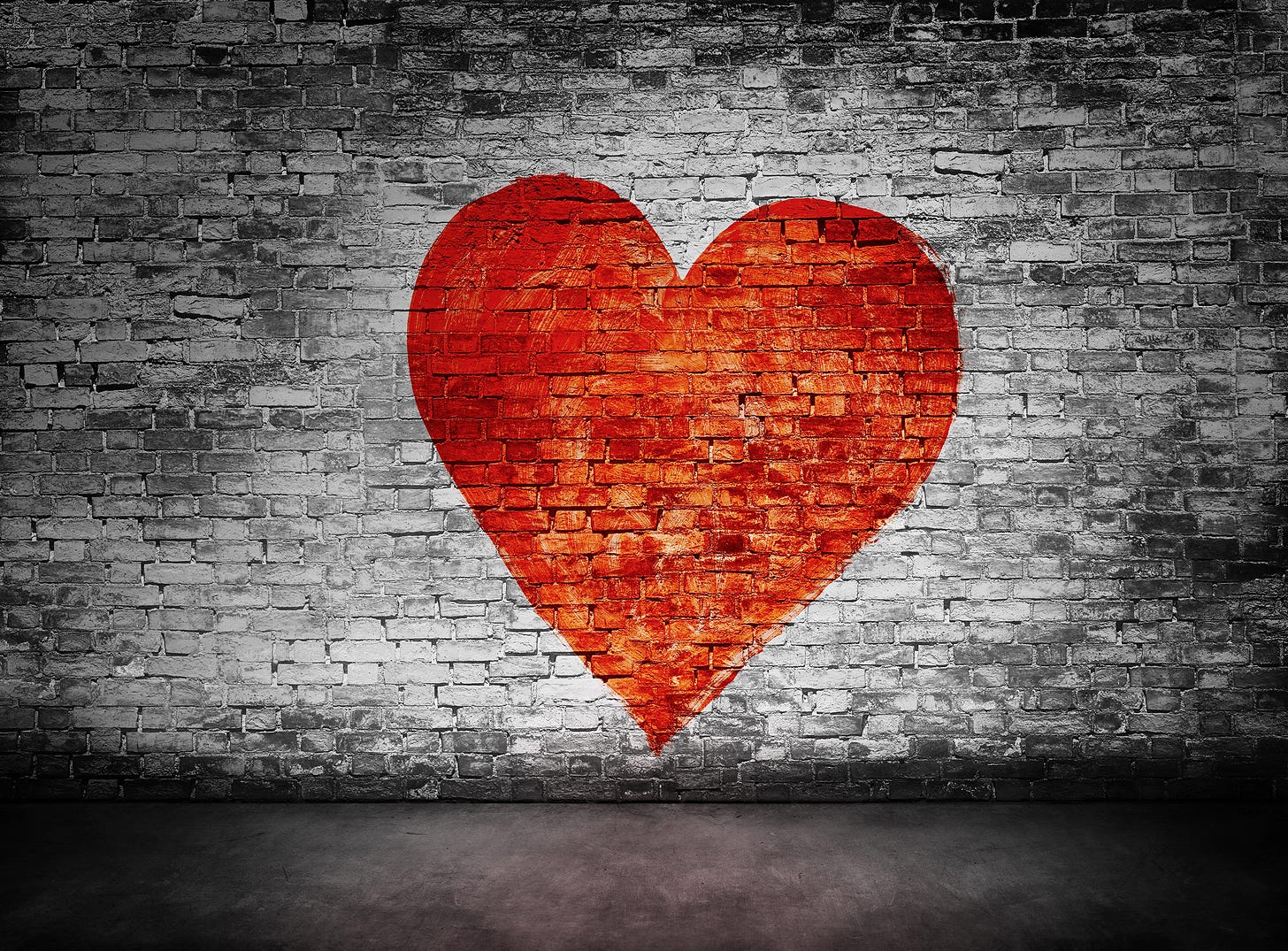 A brick wall with red heart painted on it