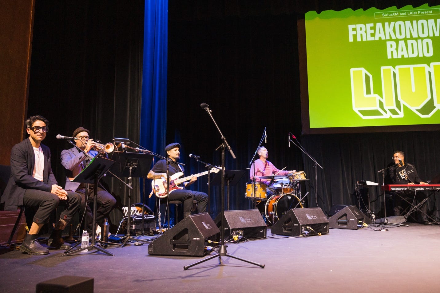 A group of people playing instruments on a stage
Description automatically generated A group of people playing instruments on a stage
Description automatically generated