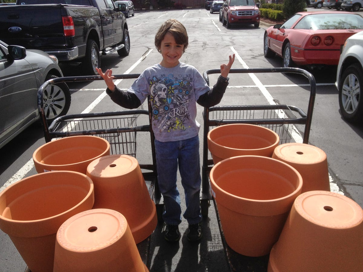 a boy and some planters in a parking lot