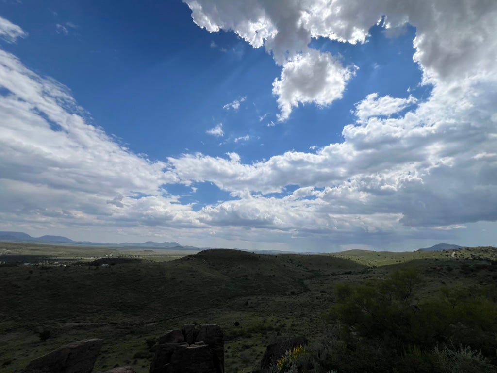 A landscape with a blue sky and clouds

Description automatically generated