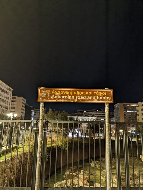 Baklava in a to-go container, a sign describing Greek ruins, and a sign in a pizza shop saying "I will always eat pizza. Always"