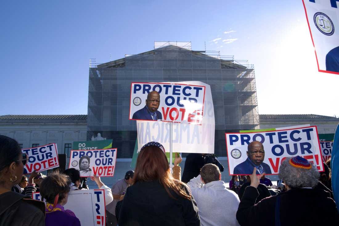 Demonstrators holding signs in support of minority voting rights gather outside the U.S. Supreme Court in Washington, D.C., on Wednesday. Some signs say "Protect our Vote."