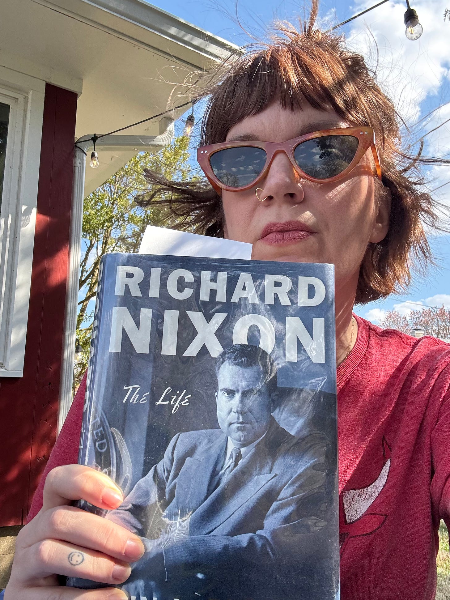 Lindsey sits outside with her Nixon book