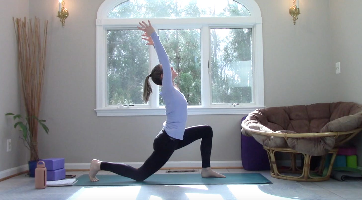 A woman in Crescent Moon Pose, lunging with one foot forward, back knee down on the ground, hands reaching up to the sky