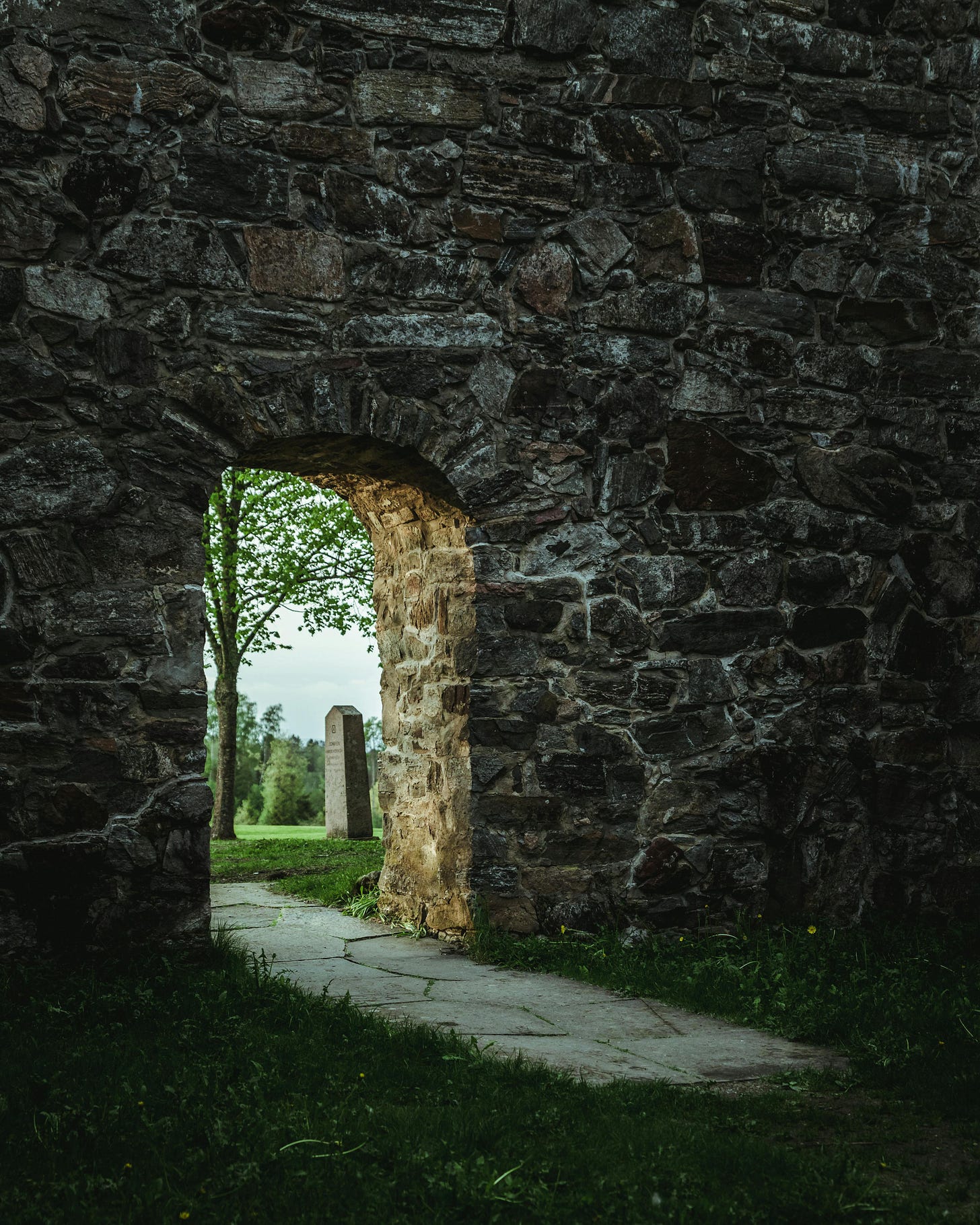Doorway through stone wall into an open field Doorway through stone wall into an open field