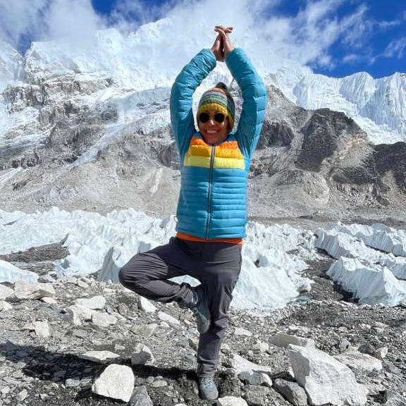 Anu performing tree pose while on a hike to Everest Base Camp