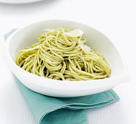 A bowl of spaghetti in pesto sauce