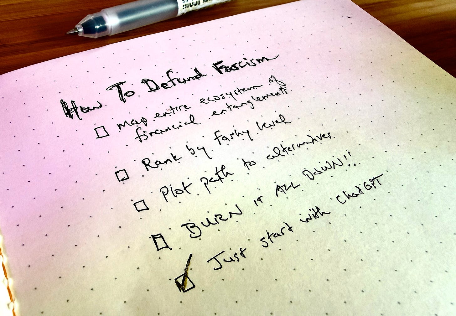handwritten notebook page with a list titled How To Defund Fascism. Underneath a checklist starting with "Map entire ecosystem of financial entanglements" followed by ""Rank by fashy level" followed by "Plot path to alternatives" followed by "BURN IT ALL DOWN!!" followed by "Just start with ChatGPT." The final item is the only one on the list checked off. Visible outside the notebook is a MUJI pen. Both items are on a wooden table.