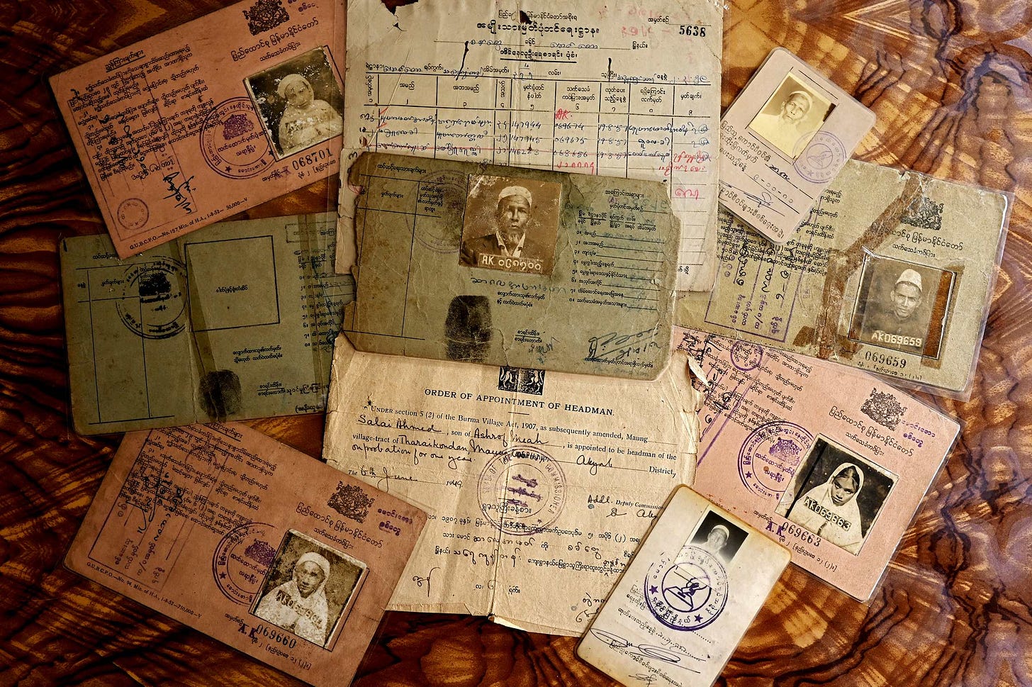 Photograph of a handful of old documents, including passports, of members of the Rohingya community.