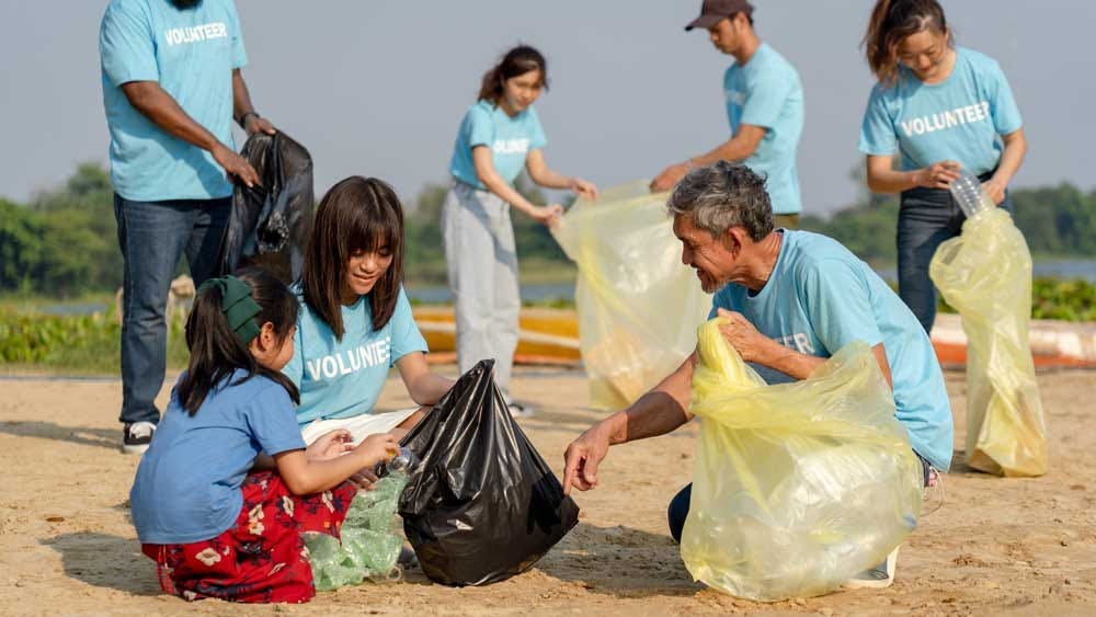 Group of volunteers cleaning a beach together. Group of volunteers cleaning a beach together.