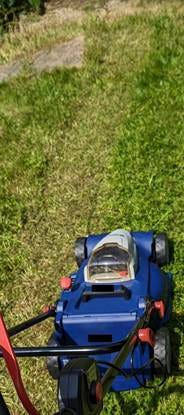 A blue lawnmower on grass

AI-generated content may be incorrect.