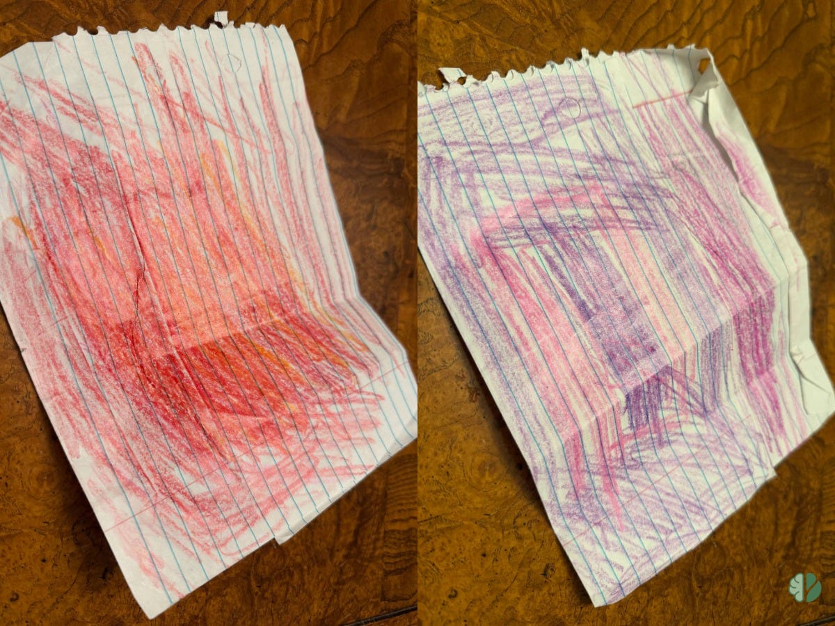 A handmade flip card on lined notebook paper. One side is filled with red and orange crayon strokes, the other with purple and blue. The paper is creased from folding. Made by a child as a way to shift from feeling overwhelmed to calm.