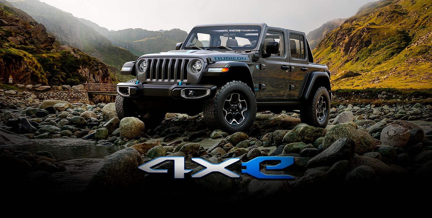 A 2022 Jeep Wrangler Rubicon 4xe parked on a rocky plateau, surrounded by mountains.