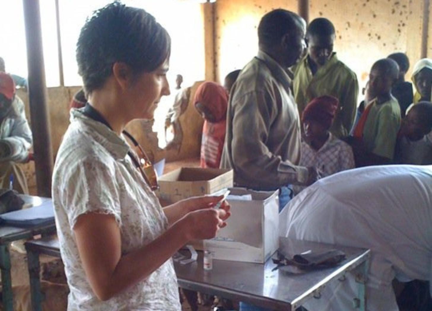 Kelly Coladarci fills a syringe of rabies vaccine at an open-air clinic, Tanzanian villagers and dogs queued behind her. Kelly Coladarci fills a syringe of rabies vaccine at an open-air clinic, Tanzanian villagers and dogs queued behind her.