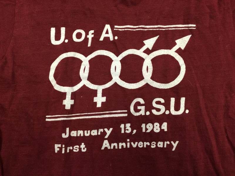 T-shirt del 1984 del University of Alabama Gay Student Union per celebrare il suo primo anniversario. Il GSU, ora Spectrum, è stato il primo gruppo studentesco LGBTQ nello stato dell'Alabama. T-shirt del 1984 del University of Alabama Gay Student Union per celebrare il suo primo anniversario. Il GSU, ora Spectrum, è stato il primo gruppo studentesco LGBTQ nello stato dell'Alabama.
