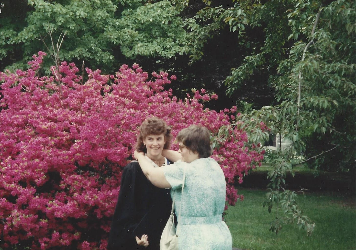 Proud mom helps adjust her daughter's graduation hood Proud mom helps adjust her daughter's graduation hood