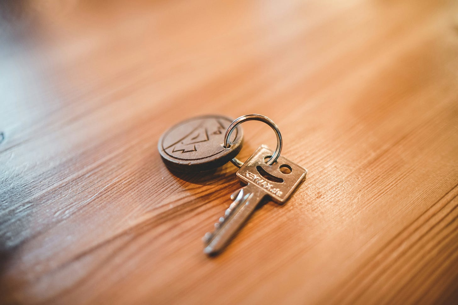 A hotel key on a wooden counter A hotel key on a wooden counter