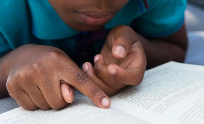 A child using the finger reading technique. A child using the finger reading technique.