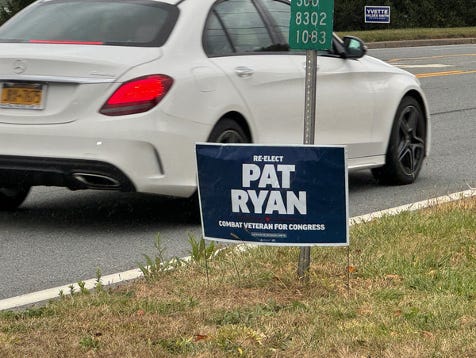 A white car drives past a Congressman Pat Ryan reelection sign. Photo for Ask a Pol by Matt Laslo © www.askapolpolitics.com