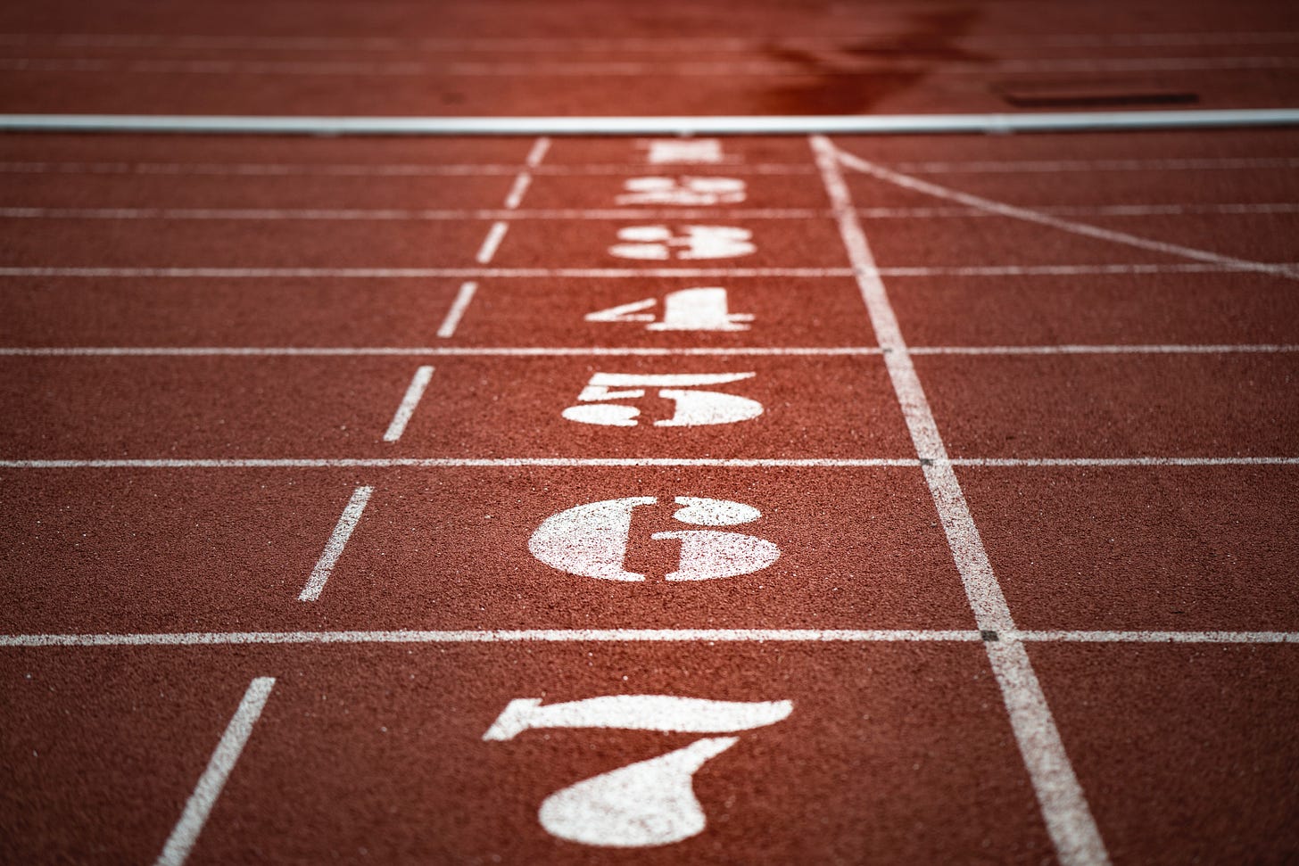 Starting block lanes on a track with the numbers 1 through 7. Starting block lanes on a track with the numbers 1 through 7.