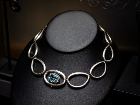 An antique opal and diamond watch in the Flames of Opal Essence exhibition, a ring by Sharvash Hakobian, a dragonfly brooch by Chong Ho, a brooch at Strong & Precious, a necklace by Jaqueline Powers, a ring by William Llewellyn Griffiths, all on show at GemGenève.