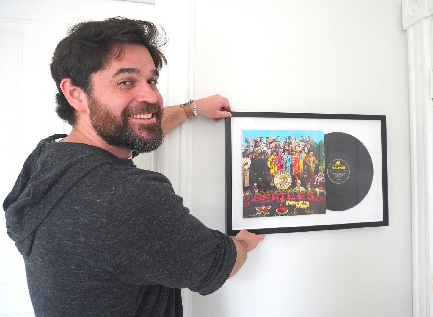 image of drew isler from Deep Cut collections showing off a piece of his art the beetles sargent pepper album image of drew isler from Deep Cut collections showing off a piece of his art the beetles sargent pepper album