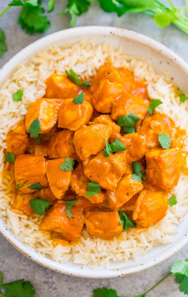 A bowl of Indian butter chicken served over rice. 