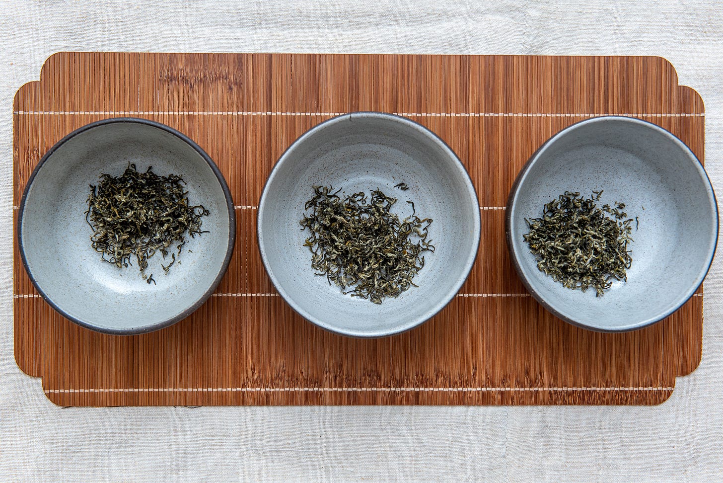 ID: Lineup of green tea leaves in bowl