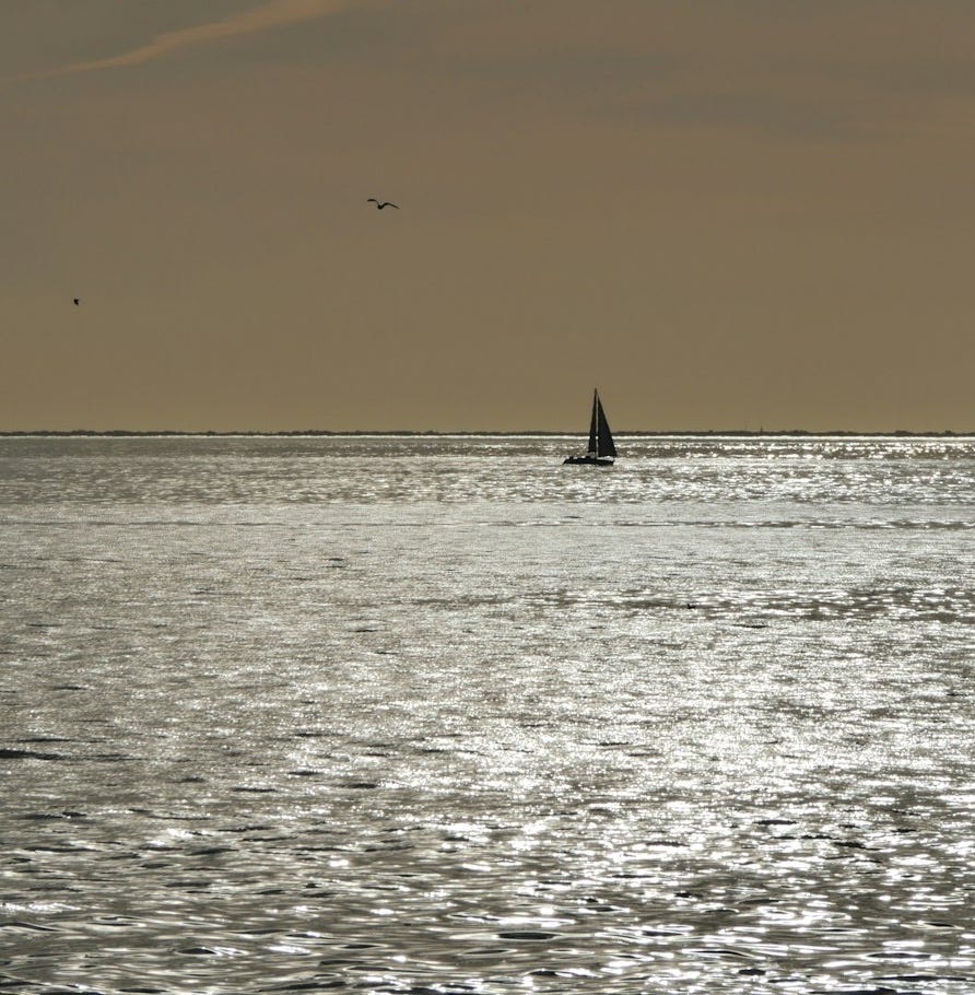white sailboat on sea under white clouds during daytime