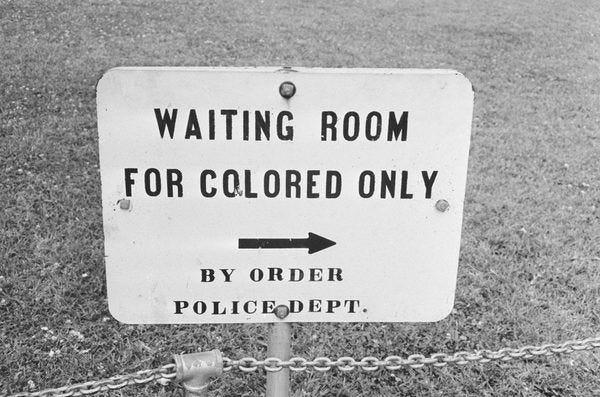 This may contain: a sign that says waiting room for colored only by order police dept on the grass This may contain: a sign that says waiting room for colored only by order police dept on the grass