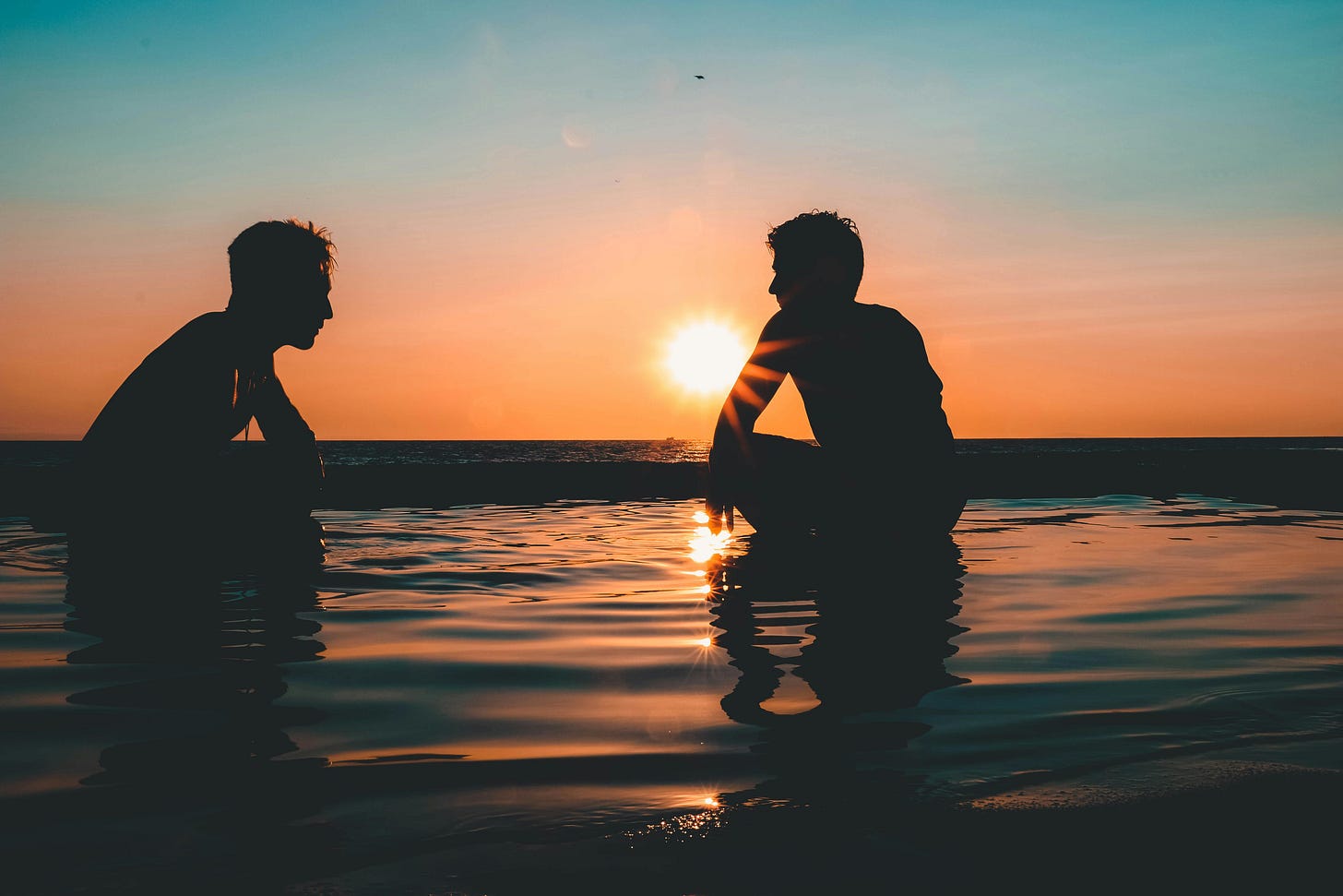 Photo of Two Men on Seashore during Sunset Photo of Two Men on Seashore during Sunset