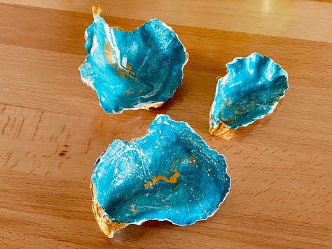 Three images of hand-painted oysters. They have paint on them in a gorgeous blend of cerulean, turquoise, gold, and white., resembling the ocean.