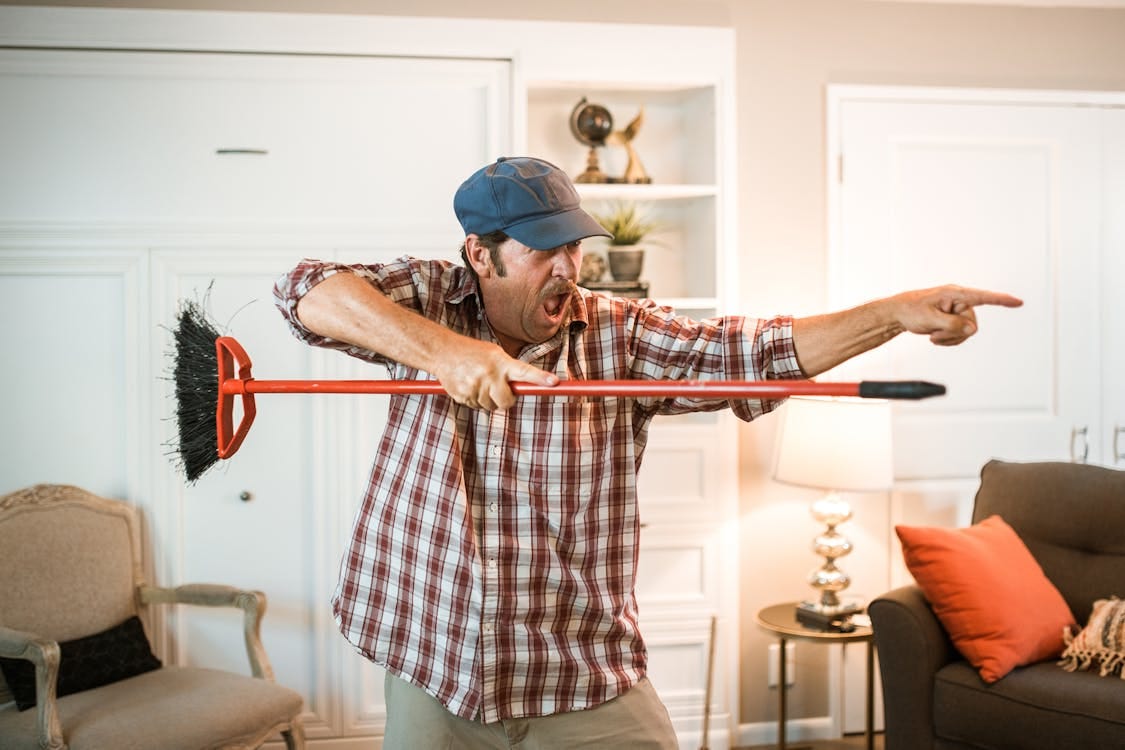 Free A senior man energetically posing with a broom indoors, showing enthusiasm and playfulness. Stock Photo Free A senior man energetically posing with a broom indoors, showing enthusiasm and playfulness. Stock Photo