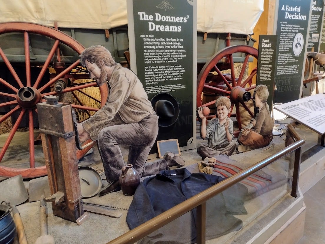 Man changing wagon wheel while children play nearby Man changing wagon wheel while children play nearby
