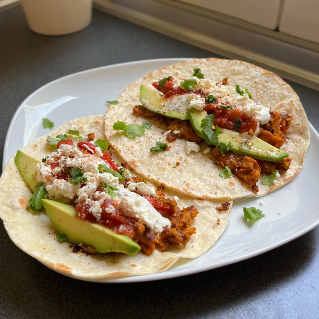 Vegan Chicken Fajita Pitas with seasoned tofu, bell peppers, avocado, vegan sour cream, and fresh cilantro