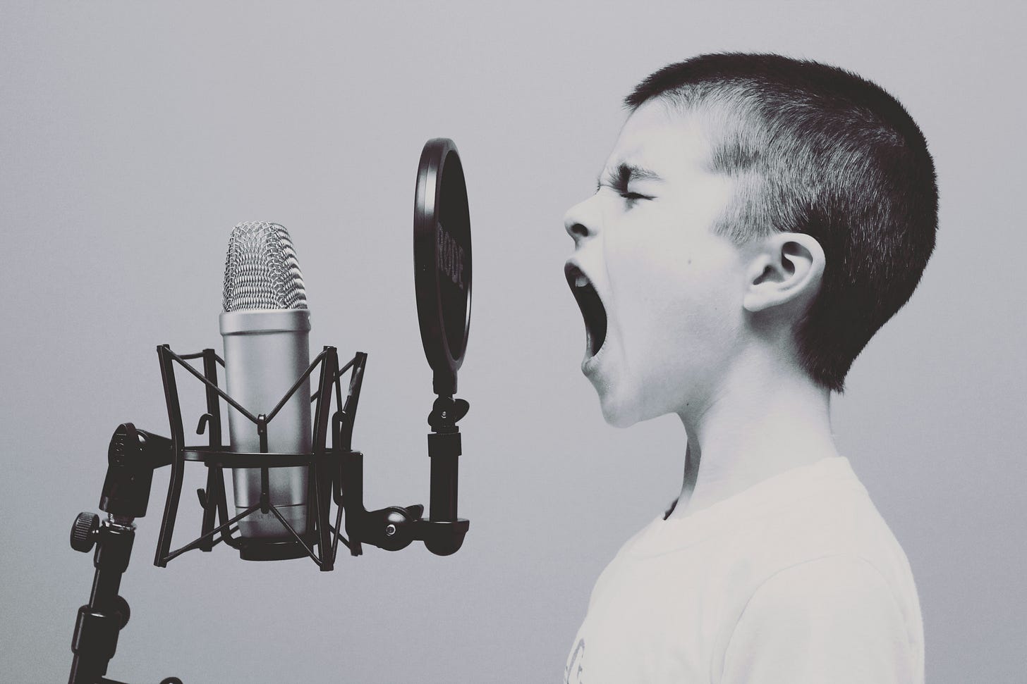 Young kid screaming into a studio microphone.