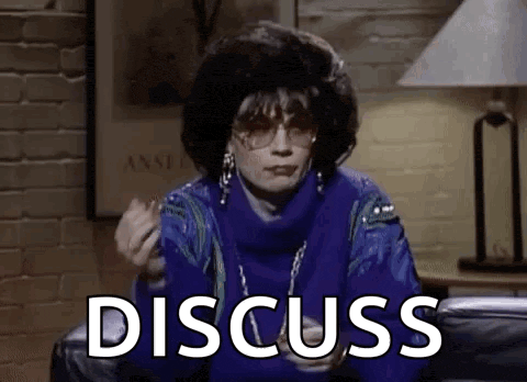 a woman in a blue sweater is sitting on a couch with the word discuss written on the screen .