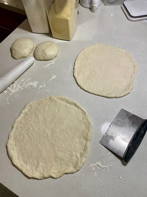 pizza dough on a counter, baked pizza sitting in a dutch oven, sliced pizza in a grey round bowl