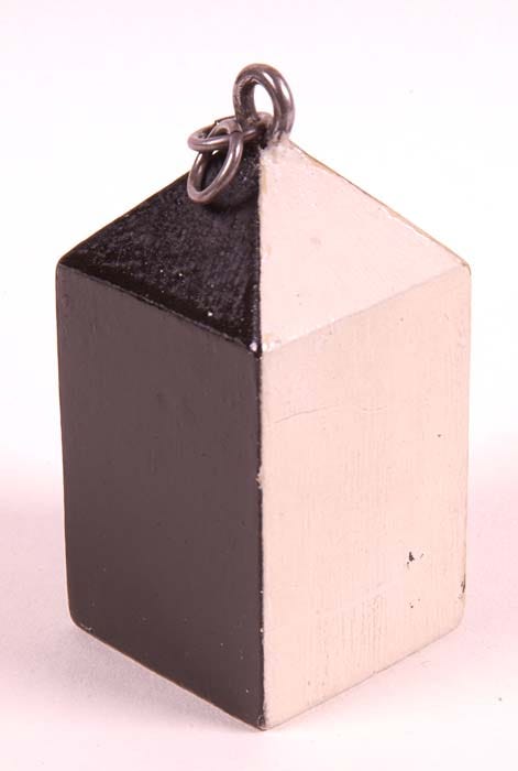 a wooden rectangular cuboid with one black and one white face showing