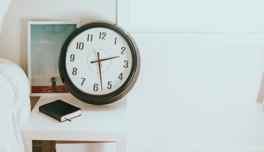 black and white round analog wall clock at 10 00