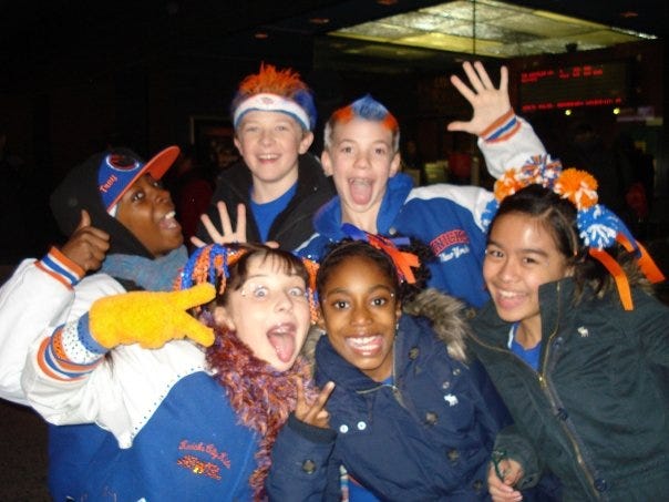 A group of kids dressed in blue, orange, and white hair accessories and spray-painted hair