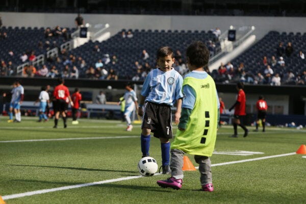A boy playing soccer in his soccer class